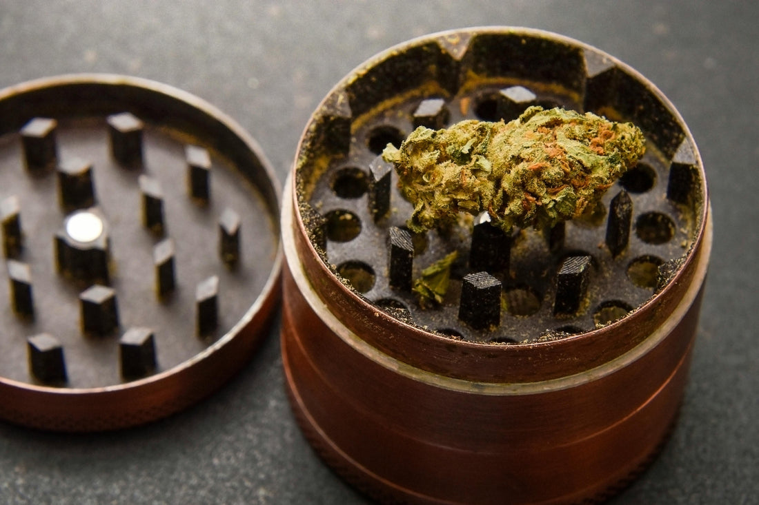 A close-up of a cannabis grinder with a bud inside.