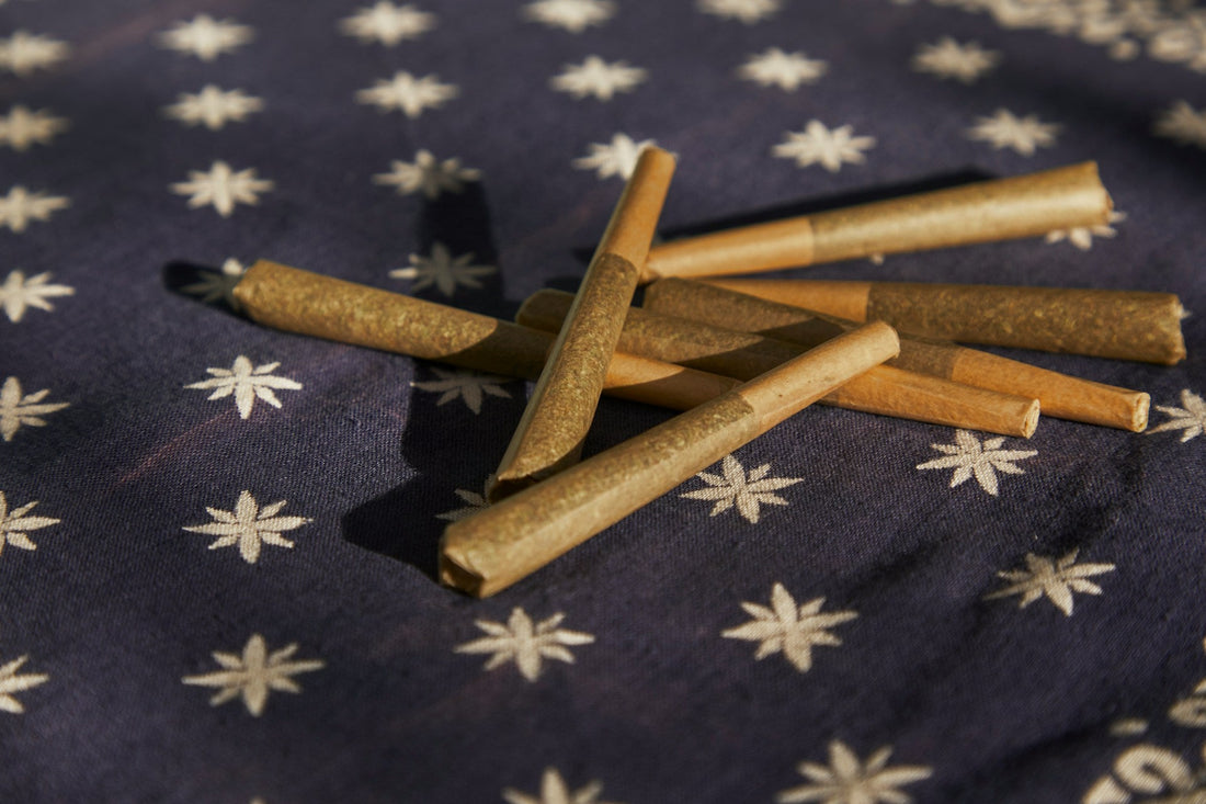 A collection of THCA pre-rolls on a patterned fabric background.
