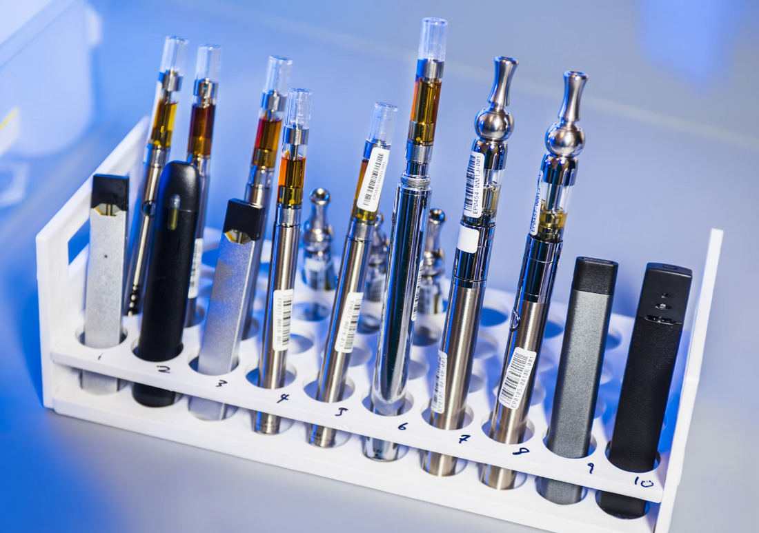 Various dab pens and vape pens displayed in a holder.