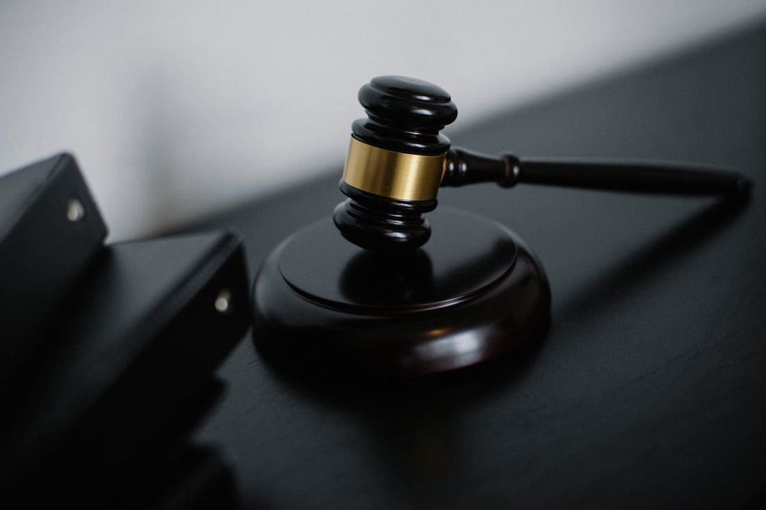A wooden gavel on a black surface, symbolizing law and justice.