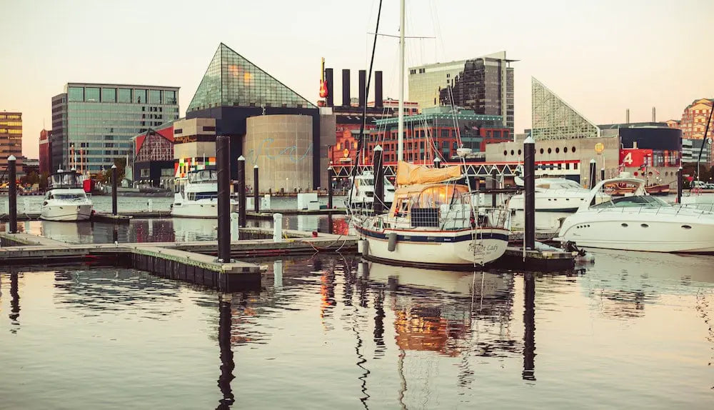 Harbor view with boats and modern buildings in Baltimore, Maryland.
