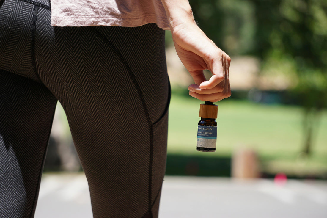 A person holding a THCA product in a natural setting.
