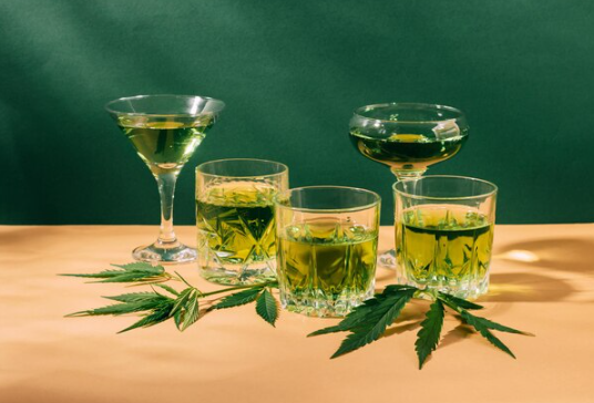 Various THC drinks displayed with green leaves on a table