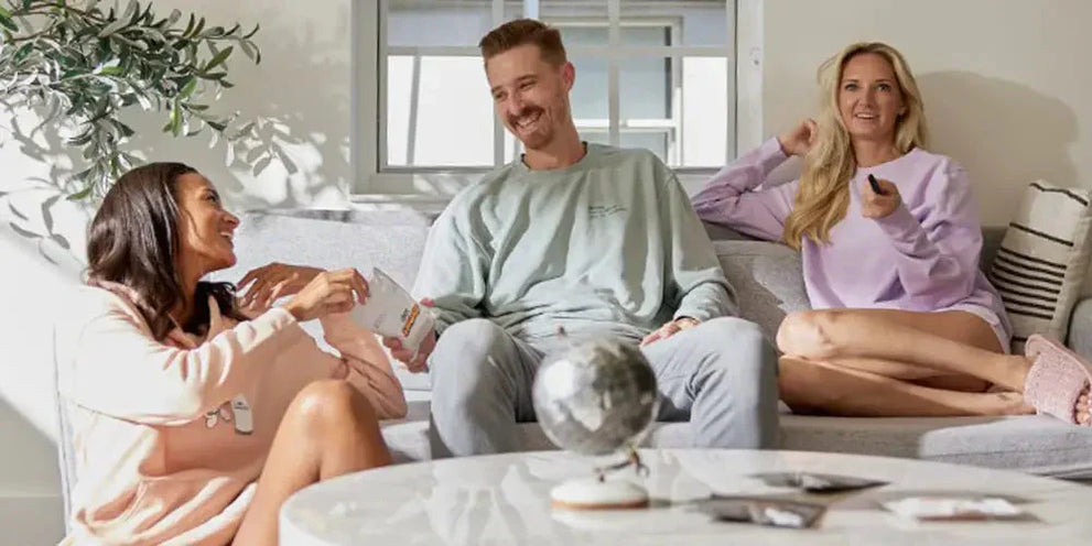 Three friends enjoying a relaxed moment together, discussing cannabis products.