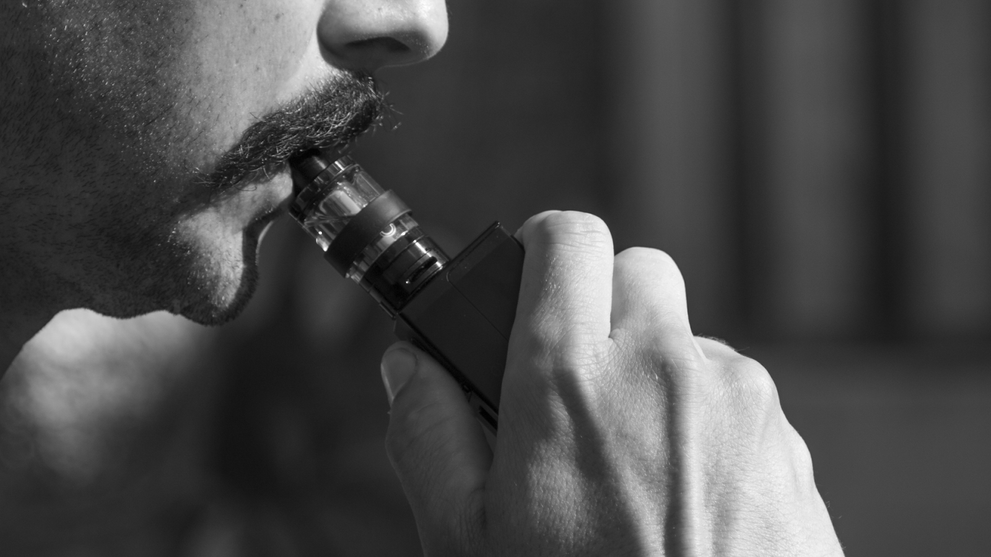 A Black And White Photo Of A Person Vaping