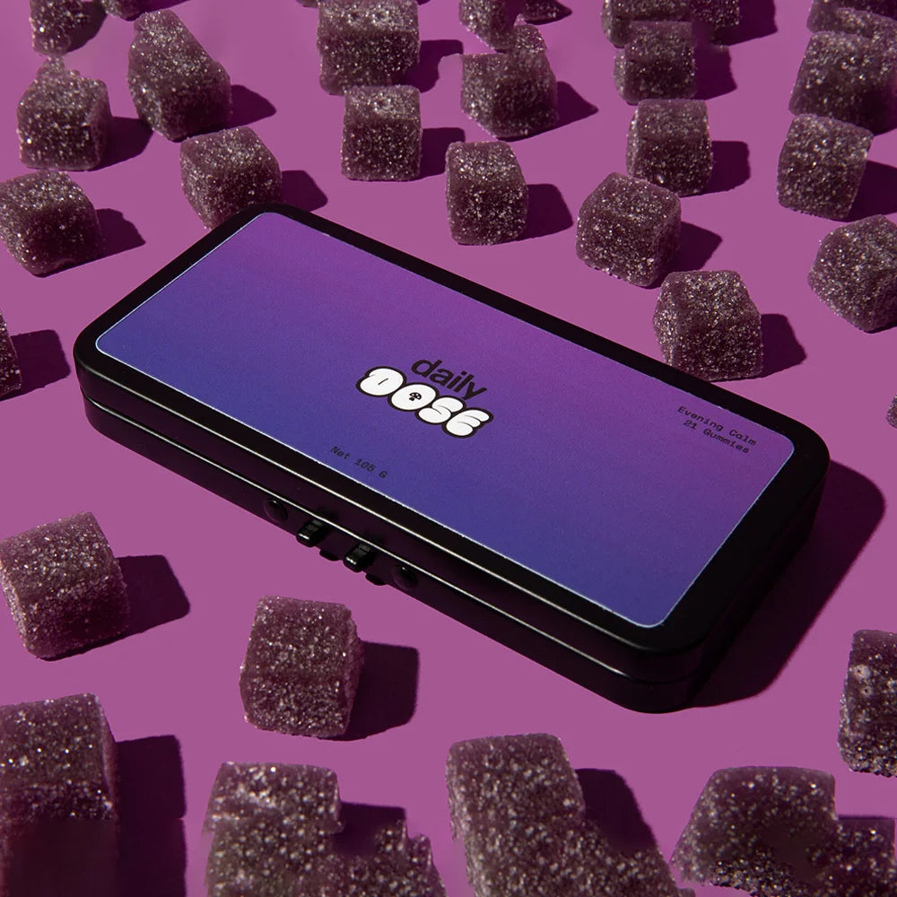 A box labeled 'daily dose' surrounded by purple gummies on a pink background.