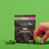 A hand reaching for green cherry lime gummies from a black package labeled 'diet SMOKE'