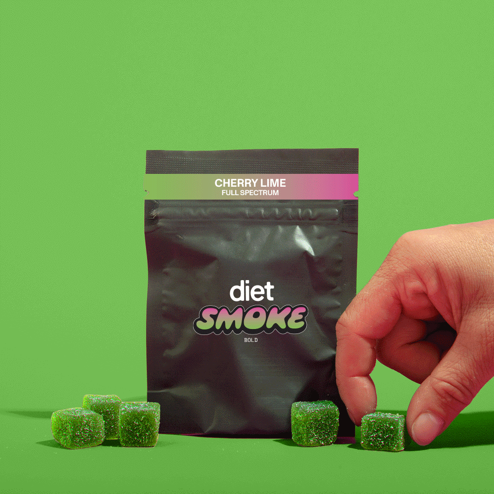 A hand reaching for green cherry lime gummies from a black package labeled 'diet SMOKE'