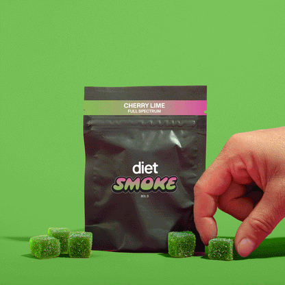 A hand reaching for green cherry lime gummies from a black package labeled 'diet SMOKE'