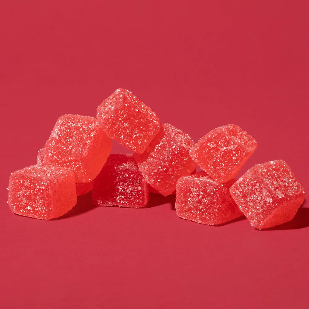 A pile of red gummy candies on a red background.