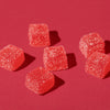 Six red gummy candies on a red background.
